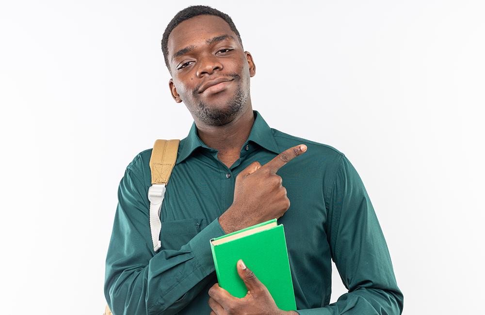 jovem-estudante-afro-americana-satisfeita-com-uma-mochila-segurando-um-livro-e-apontando-para-o-lado